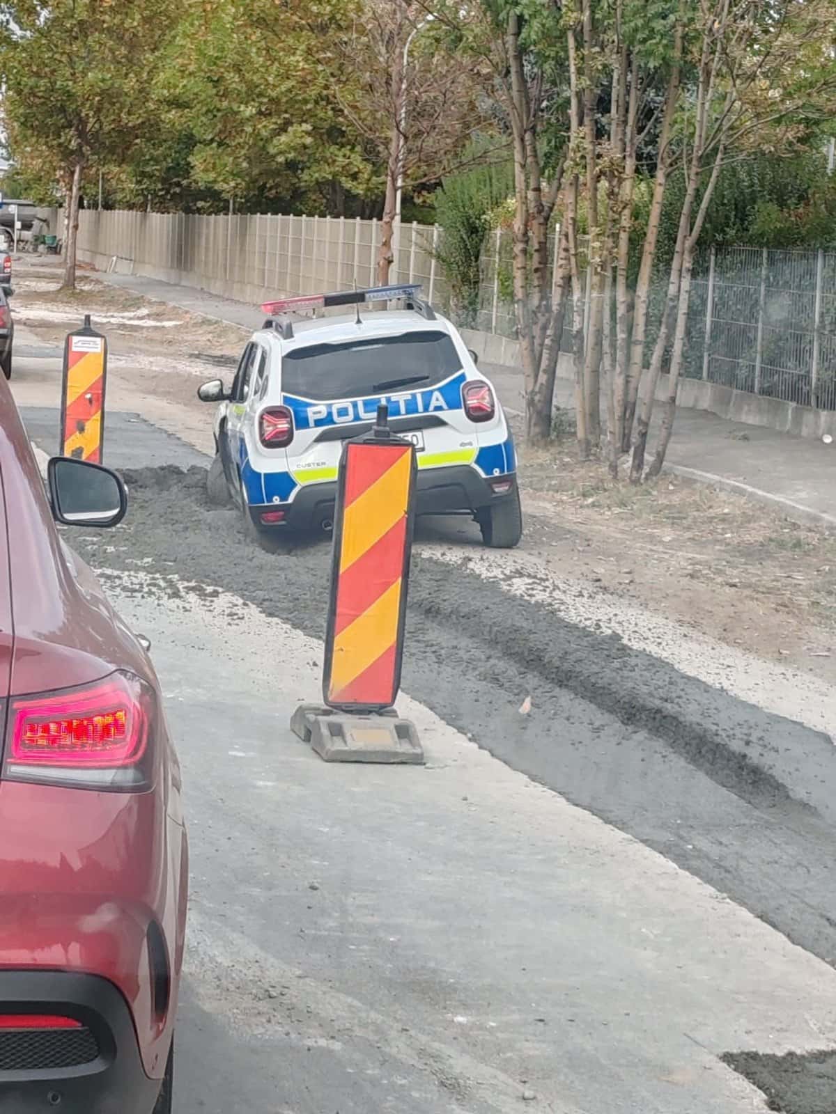 Mașină de poliție, împotmolită în asfalt